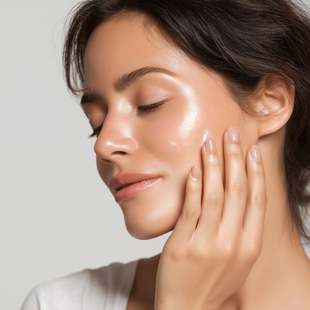 Woman with dewy, hydrated-looking skin touching her cheek – what hyaluronic acid does for skin
